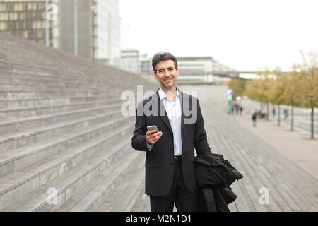 business man walking using smartphone to watch photos. Stock Photo