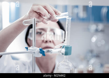 Female researcher conducting chemical experiment in laboratory Stock Photo