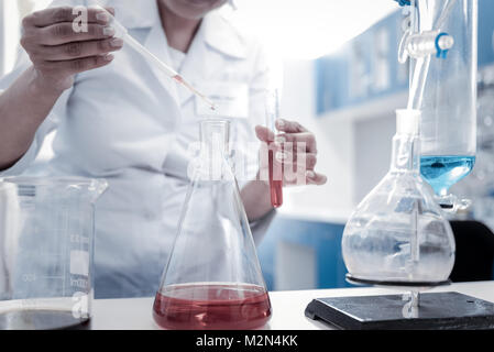 Close up of female chemist conducting experiment in lab Stock Photo