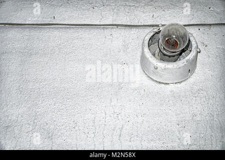 Incandescent light on an old gray wall Stock Photo