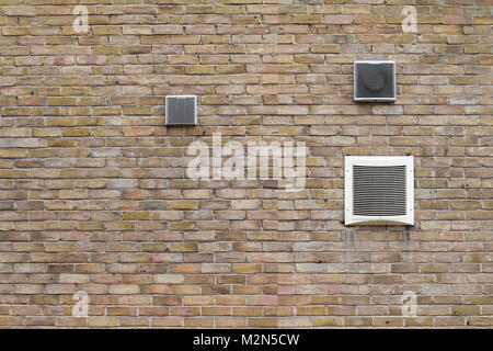 horizontal front view of air conditioning vents of different sizes on brick wall Stock Photo