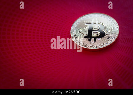 horizontal top view closeup of bitcoin golden metallic coin on red pattern background Stock Photo