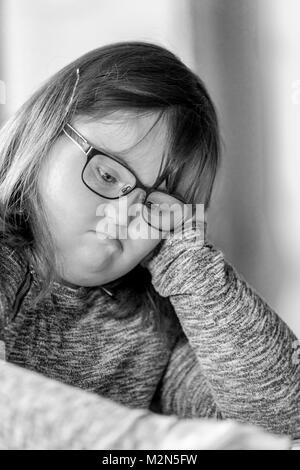 Happy child with downs syndrome always ready to help. Stock Photo