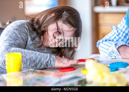 Happy child with downs syndrome always ready to help. Stock Photo