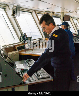 Ship's crew on bridge sailing passenger ship Ocean Adventurer; carries alpine mountaineering skiers to Antarctica Stock Photo