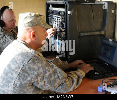 NANGARHAR, Afghanistan  (Jan. 18, 2010) - 100118-A-3421S-192: SHINWAR PROVINCE, Afghanistan – Staff Sgt. Scott F. McElroy, [headphones], of Canton, Ga. and Sgt. Angelo O. Bravo of Jasper, Ga., both 1st Squadron, 108th Cavalry Regiment, Task Force Mountain Warrior communications non-commissioned officers, finalize the setup of the Radio in a Box [RIAB] broadcast stations at the Afghan Border Police 6th Kandak headquarters in Shinwar district.  The new media program is part of the International Security Assistance Force [ISAF] counterinsurgency process and will be managed entirely by the Afghan  Stock Photo