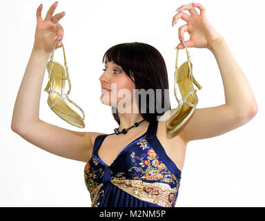 young attractive woman showing  elegant golden shoes with high heels, white background Stock Photo