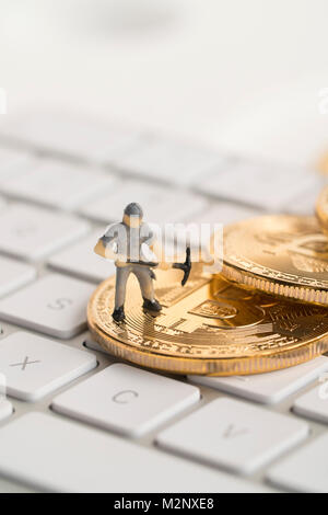 Bitcoin with little figure on keyboard Stock Photo - Alamy