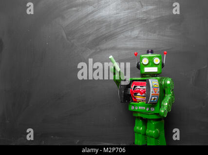 Big green robot toy teaches his class , blackboard and copy space Stock Photo