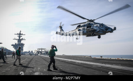 180206-N-MJ135-1141 ARABIAN GULF (Feb. 6, 2018) An MH-60R Sea Hawk, assigned to the Battlecats of Helicopter Maritime Strike Squadron (HSM) 73, takes off from the flight deck of the aircraft carrier USS Theodore Roosevelt (CVN 71). Theodore Roosevelt and its carrier strike group are deployed to the U.S. 5th Fleet area of operations in support of maritime security operations to reassure allies and partners and preserve the freedom of navigation and the free flow of commerce in the region. (U.S. Navy photo by Mass Communication Specialist 3rd Class Spencer Roberts/Released) Stock Photo