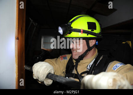 OFUNATO, Japan (March 15, 2011) - A member of the Fairfax County Urban Search and Rescue Team pries open a door, here while looking for survivors following an 8.9-magnitude earthquake, which triggered a devastating tsunami through this Japanese coastal city. Teams from the United States, United Kingdom and China are on scene to assist in searching for missing residents. (U.S. Navy photo by Mass Communication Specialist 1st Class Matthew M. Bradley/Released) 110315-N-2653B-214 by Commander, U.S. Naval Forces Japan (CNFJ) Stock Photo