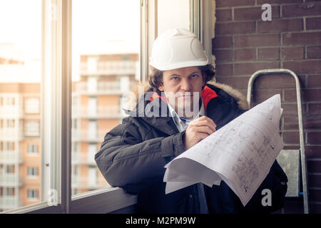 Young engineers using pen point to the blueprint paper to examine the structure of the house before presenting it at the conference. Architecture desi Stock Photo