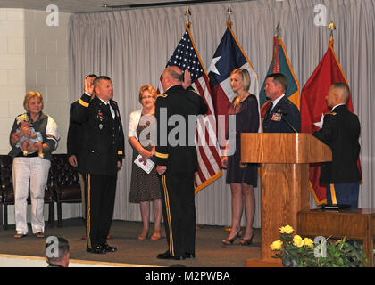 William A. Hall of Round Rock, Texas, is promoted to rank of Brigadier General in the Texas Army National Guard, and is surrounding by family while he is adminstered the oath of office by Maj. Gen. James K. 'Red' Brown, commanding general of the Texas Army National Guard's 36th Infantry Division, during a ceremony at Camp Mabry, in Austin, Texas, on June 9, 2012. Brig. Gen. Hall is the commanding general of the Texas Army National Guard's 136th Maneuver Enhancement Brigade (MEB), based in Round Rock, Texas. (National Guard photo by Staff Sgt. Phil Fountain / Released) BG Hall Promotion by Texa Stock Photo