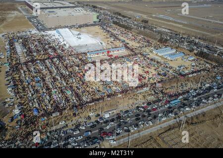 Shenyang. 8th Feb, 2018. Aerial photo taken on Feb. 8, 2018 shows people shopping Spring Festival goods at a grand fair in Yingkou City of northeast China's Liaoning Province, on the day of Xiaonian (small year). Xiaonian falls on the 23rd or 24th day of the last month of the Chinese traditional lunar calendar, marking the start of the countdown to Spring Festival. Credit: Pan Yulong/Xinhua/Alamy Live News Stock Photo