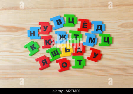 On a wooden background lies a group of letters of the Russian alphabet Stock Photo