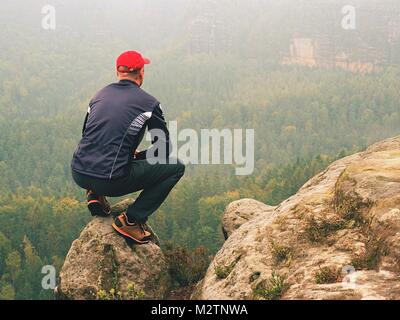 Hiker in sportswear stand on the peak of sandstone rock in rock empires park and watching over the autumnal colorful valley to Sun. Beautiful colors,  Stock Photo