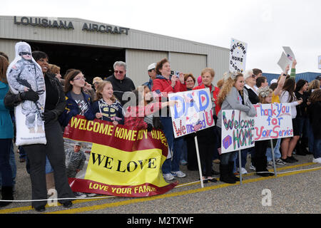 BATON ROUGE, La. – Family and friends of approximately 70 Soldiers from the 239th Military Police Company wave signs and flags to greet them as they return home at the Baton Rouge Metropolitan Airport  in Baton Rouge, La., Dec. 17, 2011. The company was deployed to Iraq in support of Operation New Dawn to conduct law enforcement operations and Police Transition Training for Iraqi law enforcement officers throughout Iraq. (U.S. Air Force Photo by Master Sgt. Toby M. Valadie, Louisiana National Guard Public Affairs Office/Released) 239th MP Co returns home from Iraq 111217-F-VU198-100 by Louisia Stock Photo