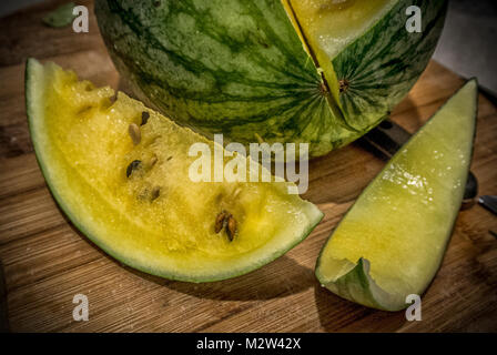 A sliced yellow watermelon on a wooden board Stock Photo