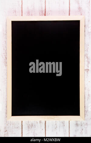 Blank blackboard on wooden table.Template mock up for adding your design and leave space beside frame for adding more text Stock Photo