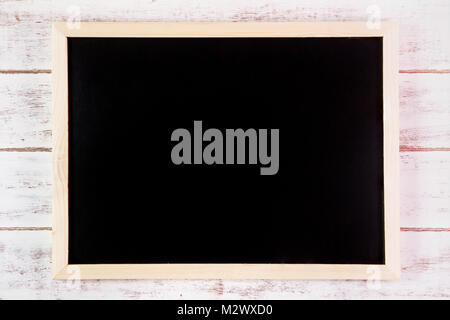 Blank blackboard on wooden table.Template mock up for adding your design and leave space beside frame for adding more text Stock Photo