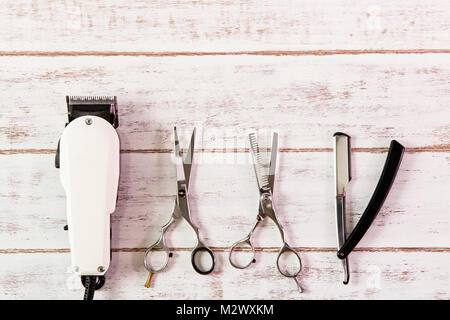 Scissors hairdresser and Clipper Barber on wooden table. Stock Photo