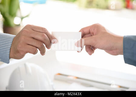 exchanging business card with engineering tools background, selective focus Stock Photo