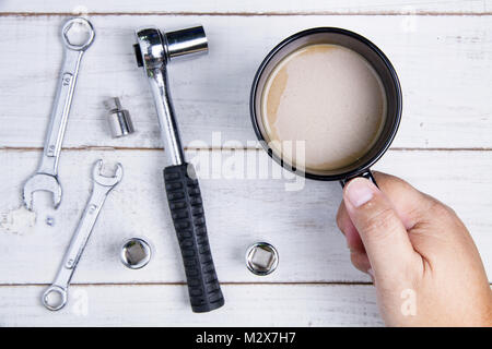 Coffee cup and equipment repair on the white wooden background. Stock Photo