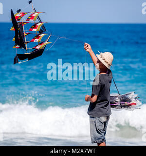 Bali, August 31, 2013: Balinese boy sells kites on the Bali beach Stock Photo
