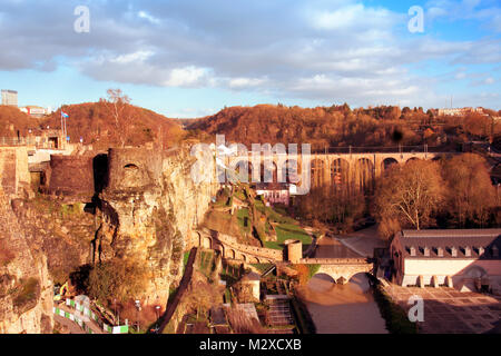 a view of the Alzette River as it passes through the Grund Quarter in Luxembourg City, Luxembourg, highlighting the remains of the ancient fortress in Stock Photo