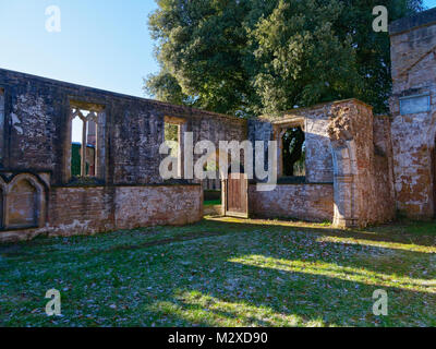 Sunlight streams through the glassless windows of a ruined medieval church Stock Photo