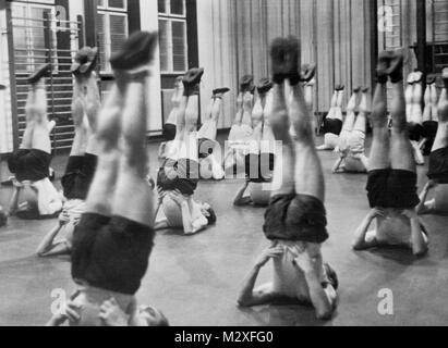 Upside down men in gym class, ca. 1935. Stock Photo