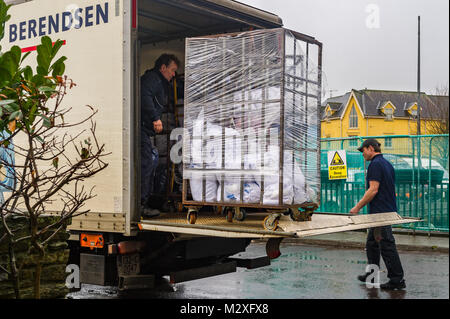 Linen being unloaded from a truck by two men in Skibbereen, County Cork, Ireland. Stock Photo