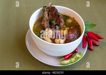 Soup with white and red beans, other vegetables and smoked pork ribs. With an accent of red and green hot peppers. Stock Photo