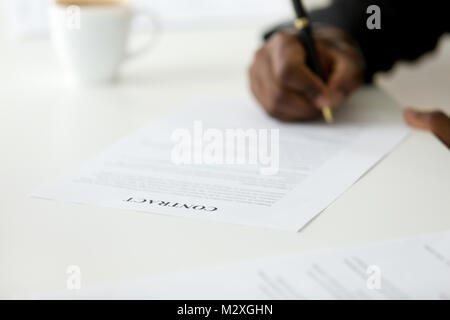 Contract close up view, african american businessman signing business legal paper concept, black man agree on terms and conditions taking contractual  Stock Photo