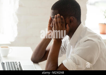 African american businessman feeling headache migraine at work touching temples, stressed tired upset black man feeling dizzy or depressed and frustra Stock Photo