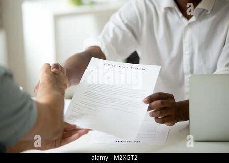 African american employer holding employment agreement offering new job welcoming successful vacancy candidate, black recruiter and white employee sha