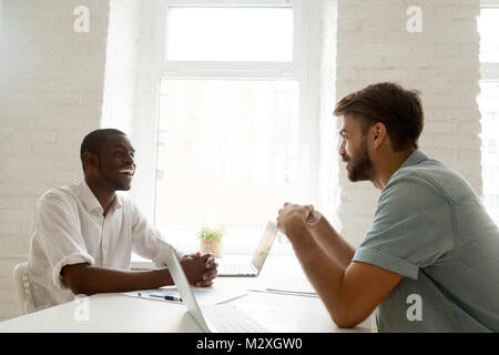 African-american and caucasian businessmen talking laughing havi Stock Photo