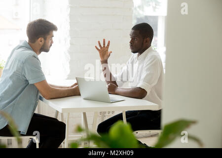 Focused african manager explaining making business offer to cauc Stock Photo