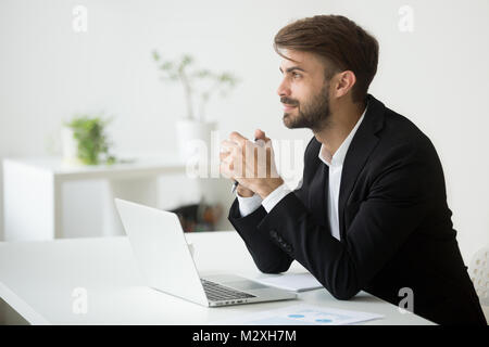 Dreamy businessman thinking of business idea planning future at  Stock Photo
