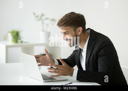 Happy surprised businessman looking at laptop excited by online  Stock Photo