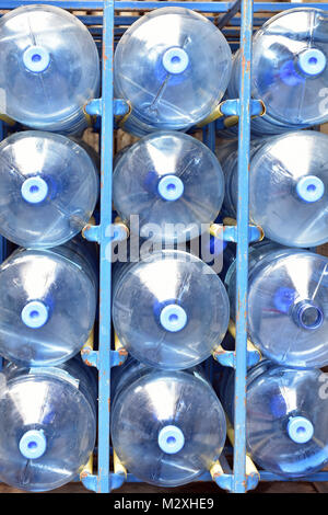 Large plastic water bottles being collected and delivered to a business premises in metal cages. Plastics damaging the environment and recycling used. Stock Photo