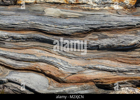 Layered bands of metamorphic rocks with quartz intrusions and Stock ...