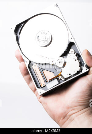 Disassembled hard disk drive in male hand on white background Stock Photo