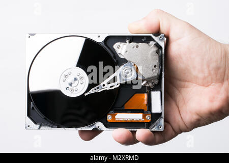 Disassembled hard disk drive in male hand on white background Stock Photo