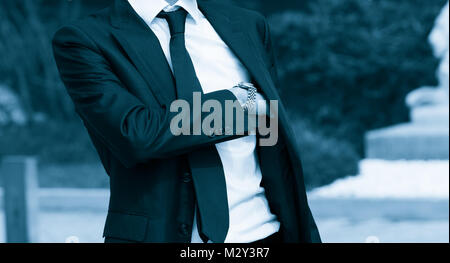 Elegant man taking a gun from his suite. Secret agent concept. Blue Toned Image. Stock Photo