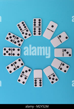 Clock fase made of domino plates on blue background Stock Photo