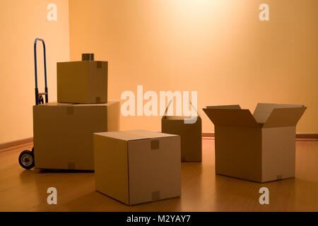 Boxes in an empty room representing concept of home moving Stock Photo