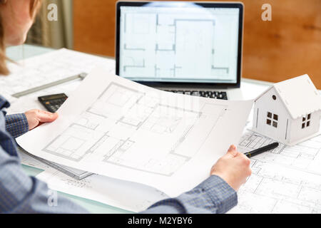Young female architect and designer working on blueprint project of new apartments. Photo concept of work on technical drawings Stock Photo