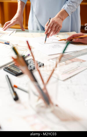 Interior designers working on hand drawings of  interior at work place. Photo of young designers work concept Stock Photo