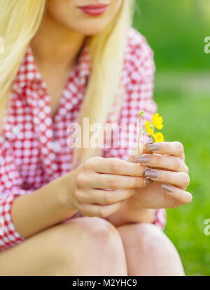 Young woman holding a yellow flower in the hand Stock Photo